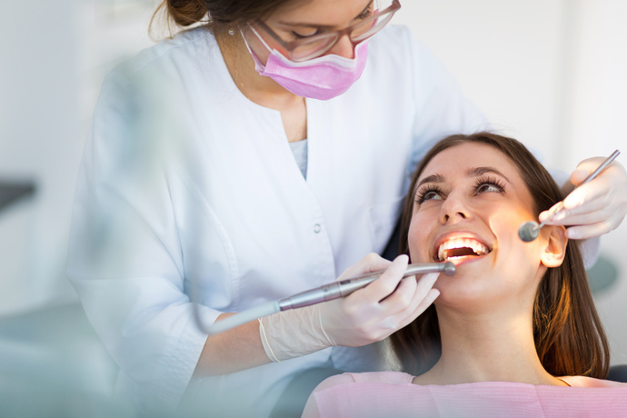 Mujer dentista extrayendo las muelas del juicio de un paciente.