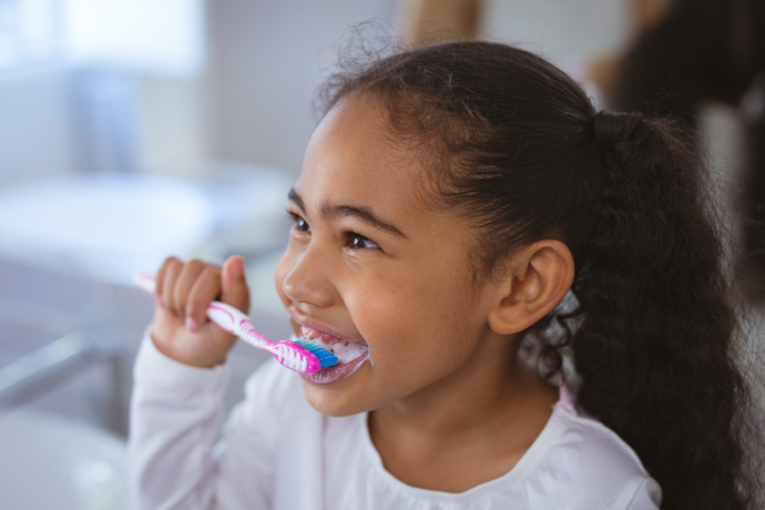 Niña lavándose los dientes para su higiene personal